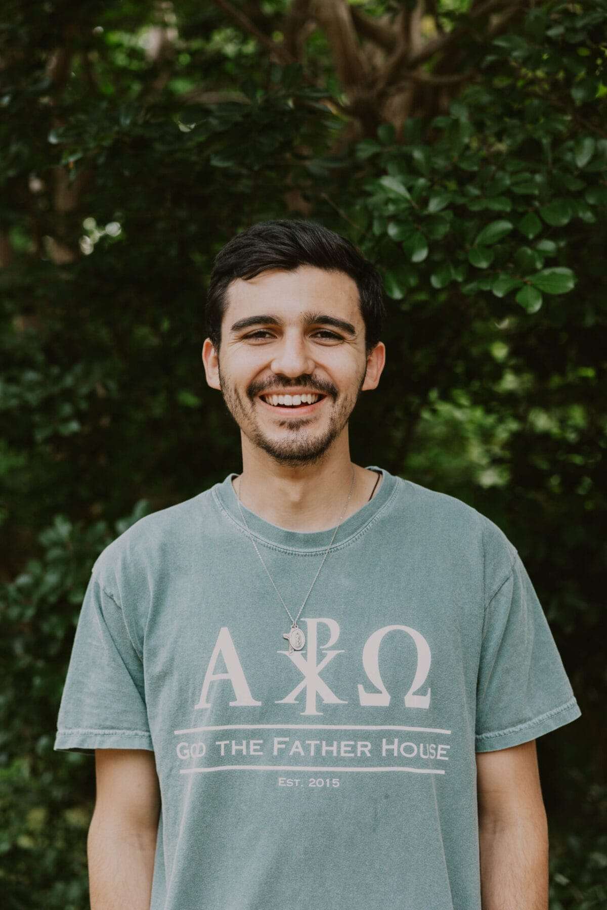 A man in a t-shirt smiles at the camera.