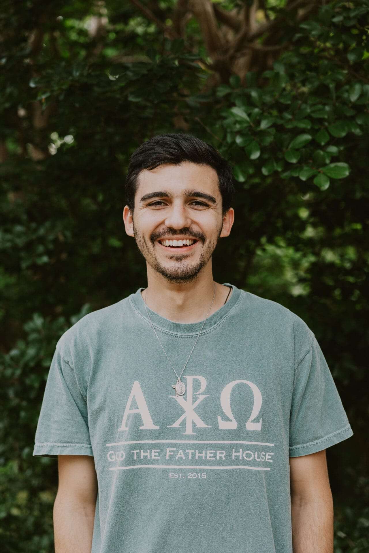 A man in a t-shirt smiles at the camera.