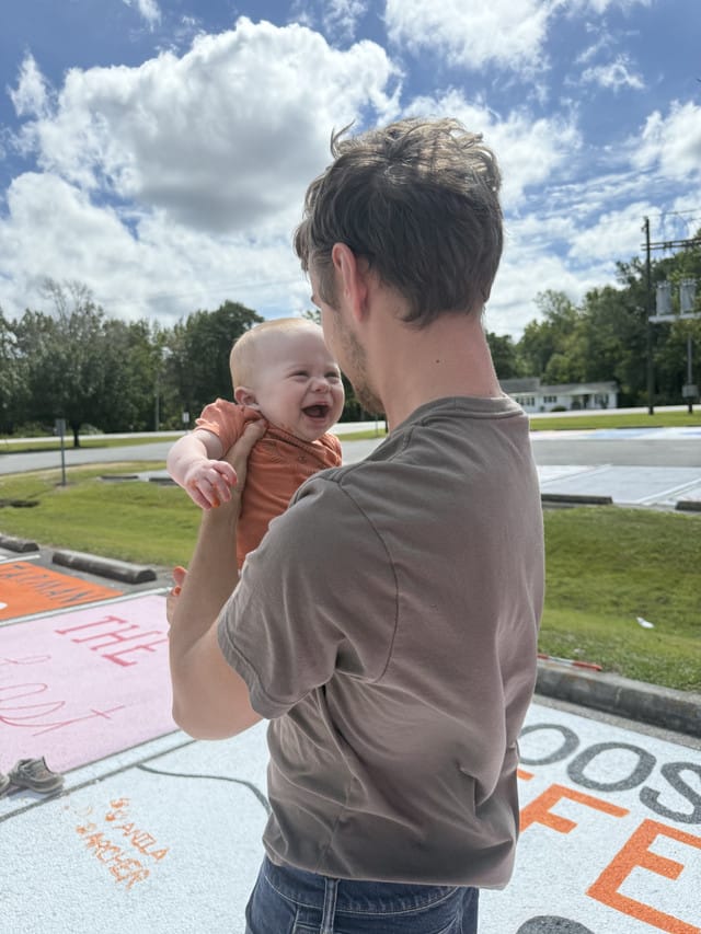 A man holds a smiling baby.