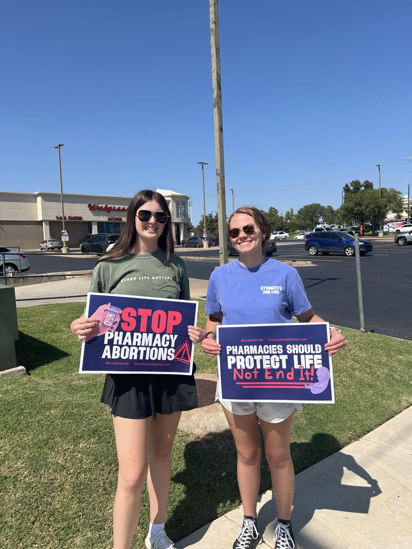 Two women hold anti-abortion signs.