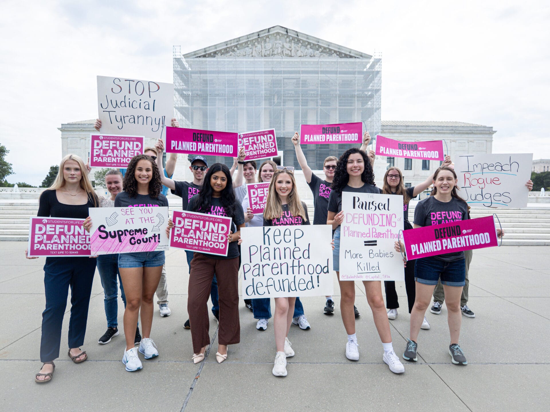 A group of people hold signs.