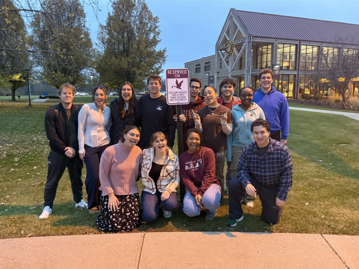 A group of people pose for a photo. The front row is kneeling.